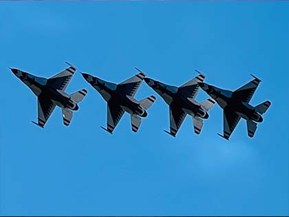 4 USAF Thunderbirds flying through blue sky